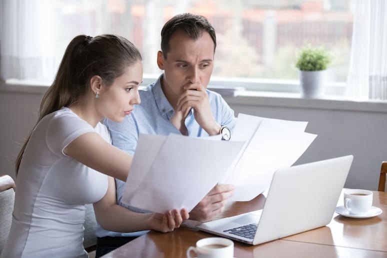 couple looking at credit report and bills